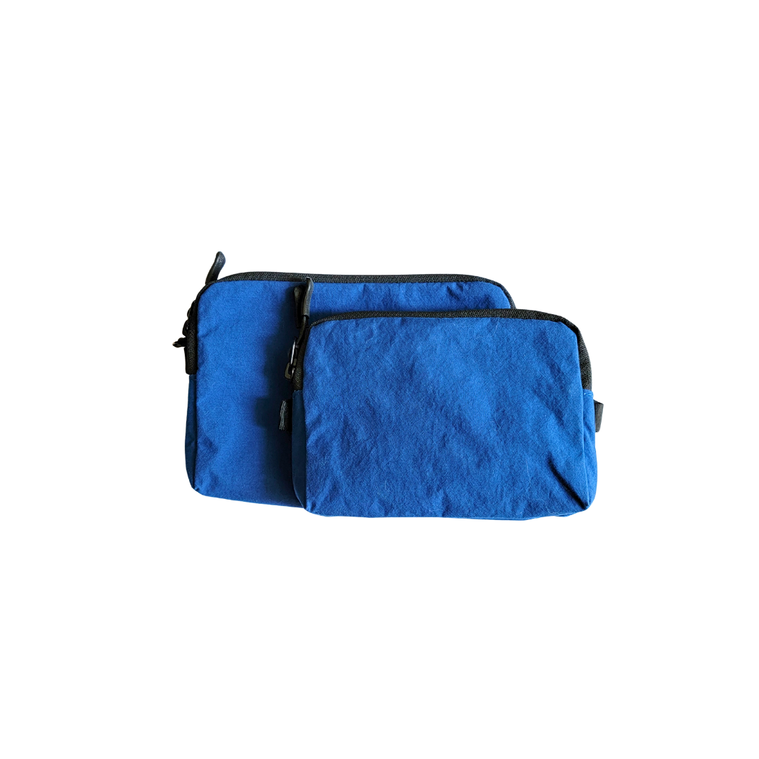 Two blue pouches with black zippers on a white background